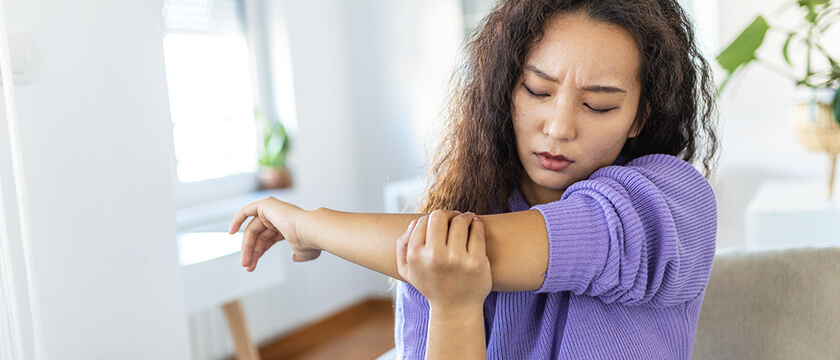 Woman Grasping Elbow in Discomfort