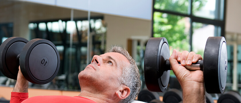 Man in a Red Shirt Lifting Weights (Dumbbell Press)