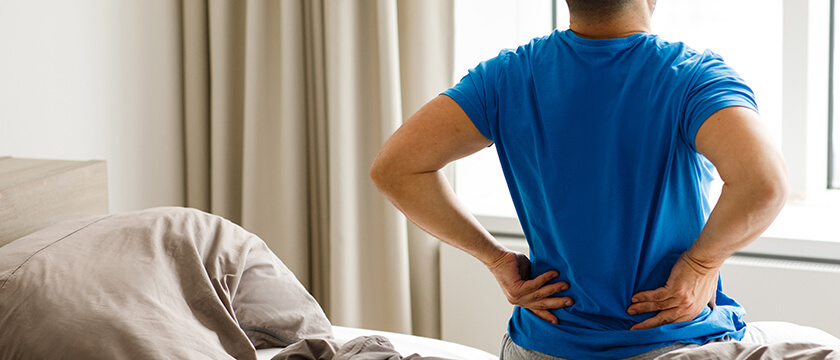Man Getting Out of Bed with Back Pain