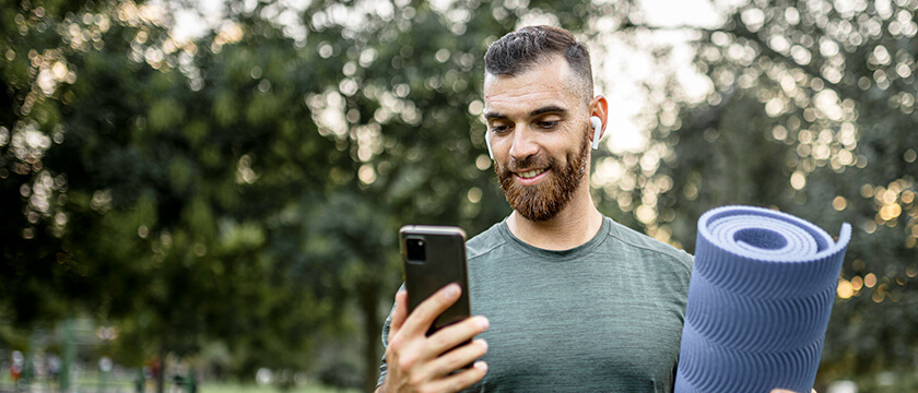Man Looking at His Phone with a Yoga May