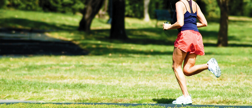 Woman Running Along a Park Path