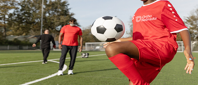 Soccer Player Doing a Knee with Ball
