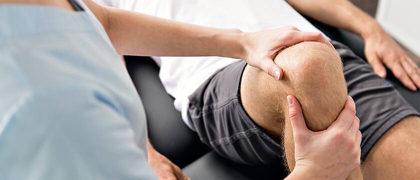 Physcial Therapist Working on a Patient's Knee