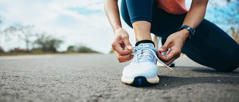 Woman Tying Shoe on Road, Clear Day