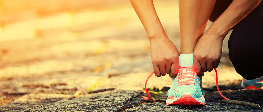 Woman Tying Athletic Shoes with Strong Hands