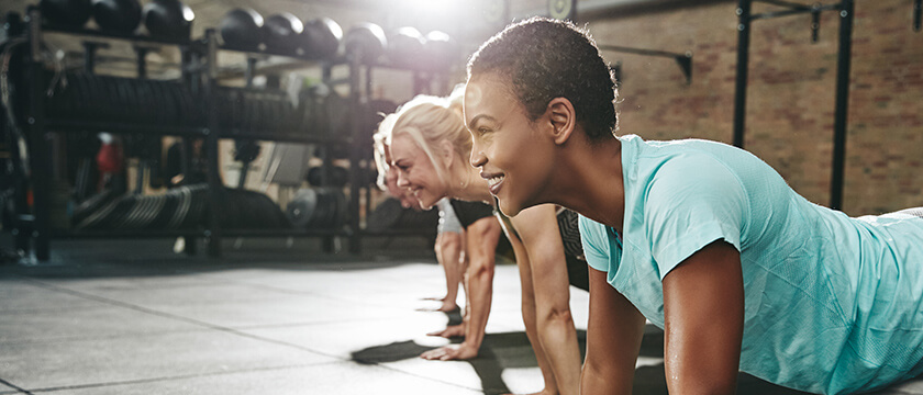 Women in a Fitness Glass or Gym Setting Doing Push Ups
