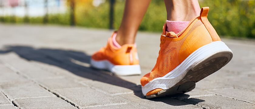 Woman Walking with Good Foot Arch on Street with Orange Shoes Close Up