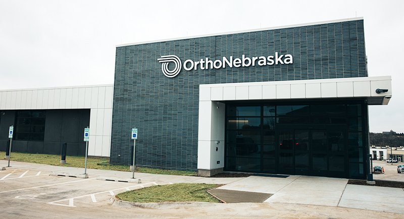 West Maple Building Entrance: Grey exterior with white awning and black glass entrance