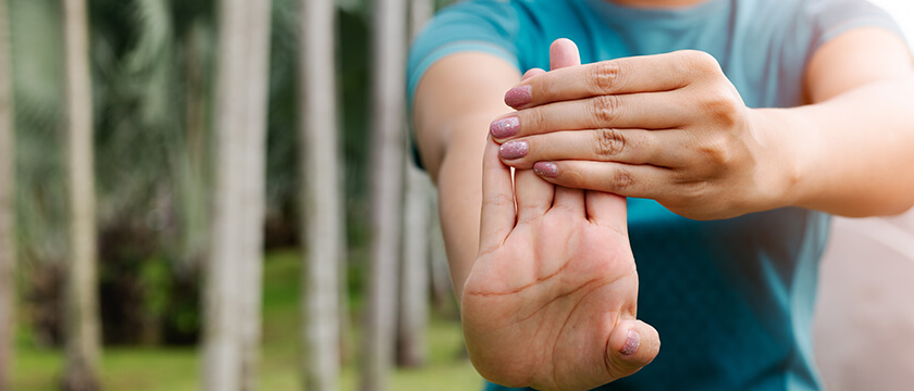 Woman Flexing Her Wrist in Woods