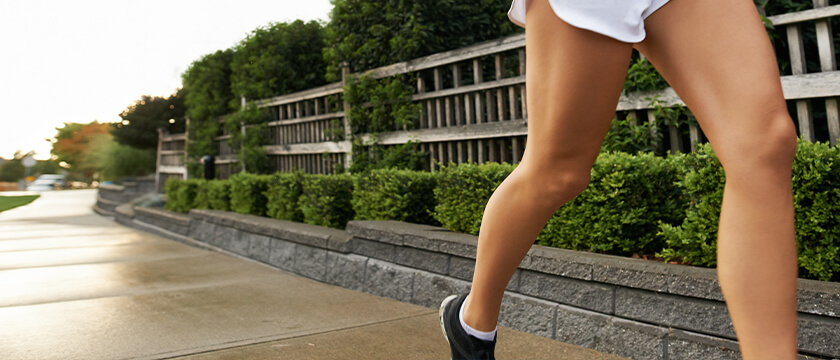 Young Woman's Legs as She Jogs Down a Street