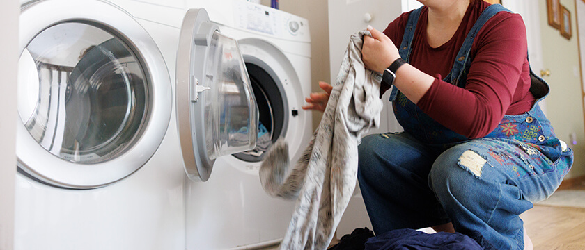 Woman Kneeling by Washing Machine