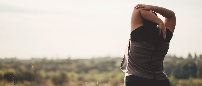 Woman Outdoors Stretching Her Arm