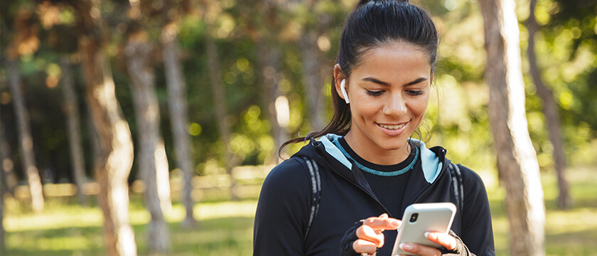 Woman Outdoors, Looking at and Using Mobile Phone