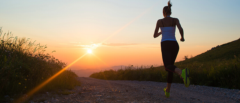 Woman Running on a Country Road at Sunset