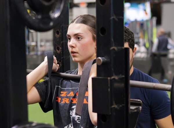 Young athlete using weight equipment in gym
